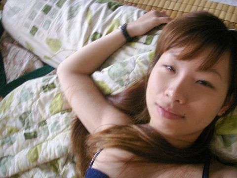 Азиатка делает селфи для парня, развалившись в постели